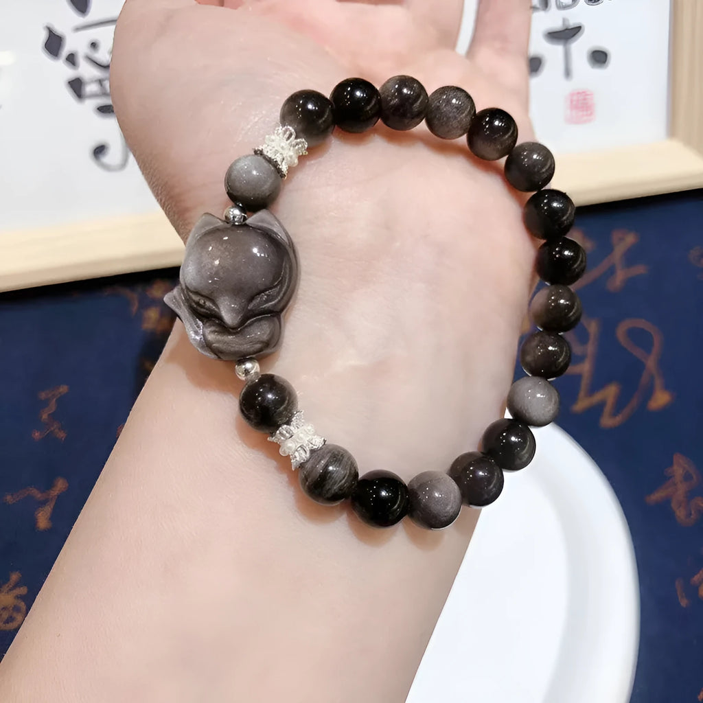 Natural silver stone big head fox bracelet with 8mm obsidian beads on a white background