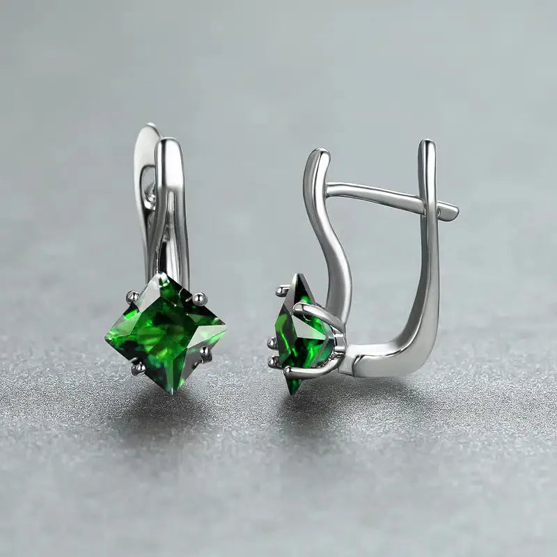 A pair of copper diamond-shaped earrings with inlaid zircon stones, shown in blue, green, and colour variants.