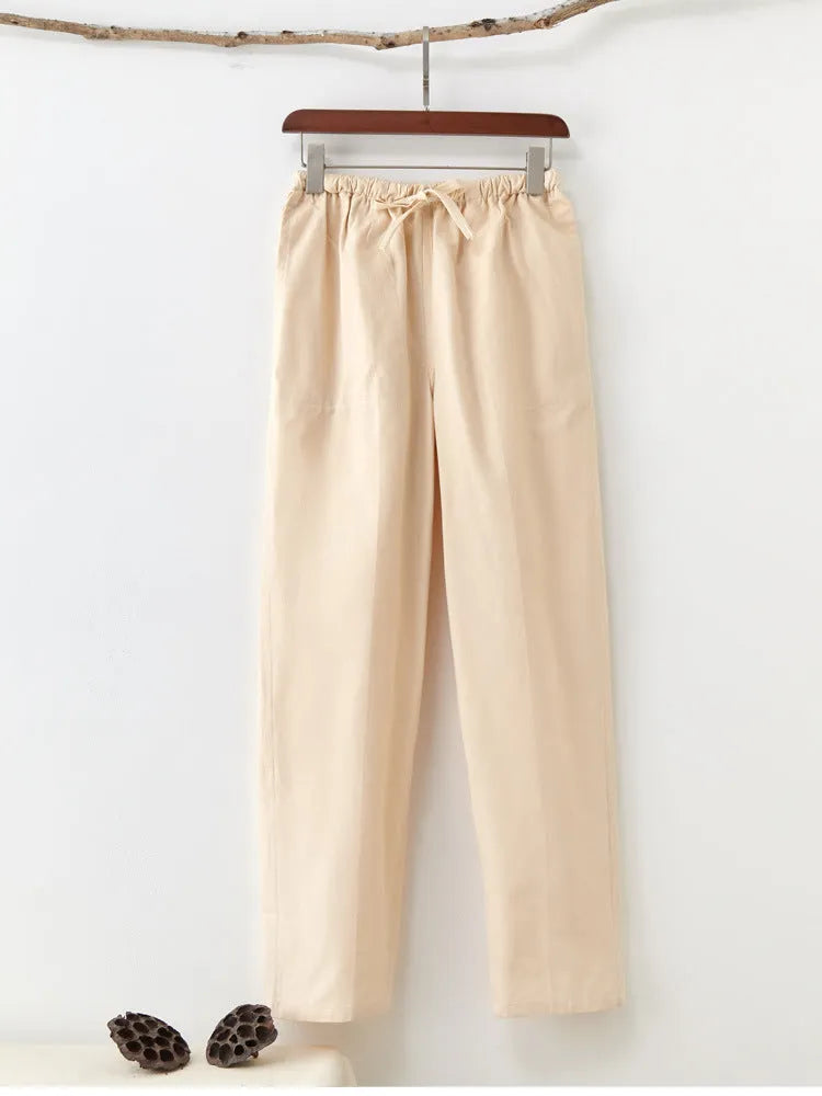 Man wearing beige pure cotton casual trousers with a drawstring waist and belt.