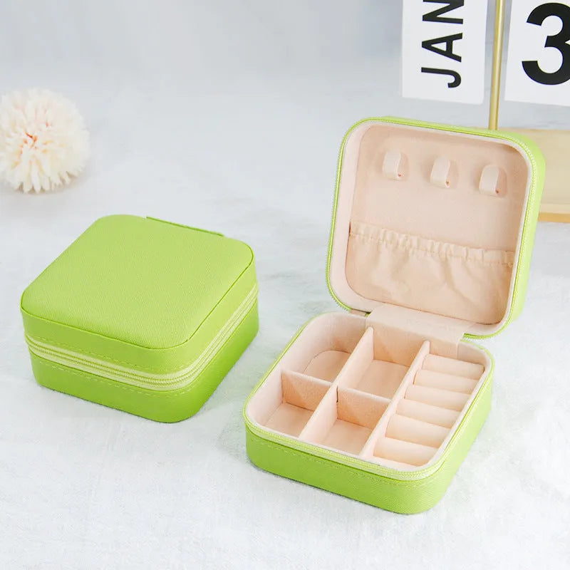 Small leather jewellery box in cross pattern, 10cm size, for earrings and rings, on a flat surface.
