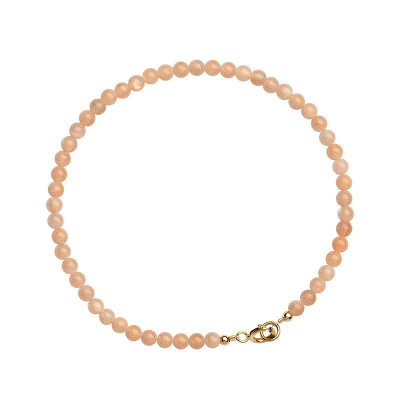 Close-up of a women's bracelet with small 3mm sunstone crystal beads on a wrist, showing its thin profile.