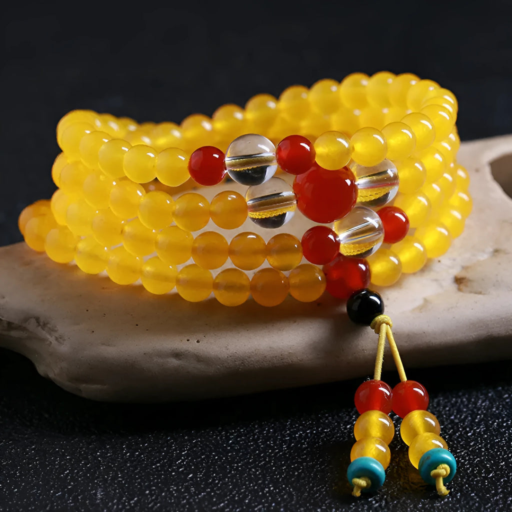 Women's geometric crystal necklace with lucky cat charm alongside 108 agate and canary stone beads