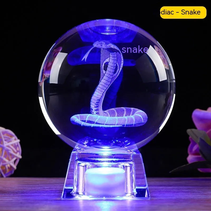 White crystal ball zodiac ornament with luminous electronic base showing Chinese animal designs