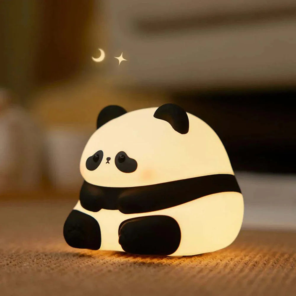 Cartoon panda rechargeable night light with soft silicone body on a wooden table