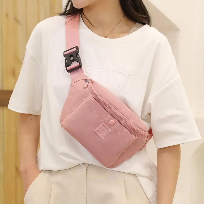 Women's nylon crossbody fanny pack in black with zippered compartments and letter detail.