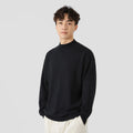 A man's loose-fitting, long-sleeve pullover sweater in a solid colour, showing a casual relaxed fit.