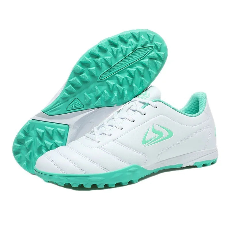 Low-top outdoor soccer shoes in a black and blue broken nails colourway on a turf background.