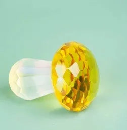 Colourful transparent crystal mushroom decoration on a white background.