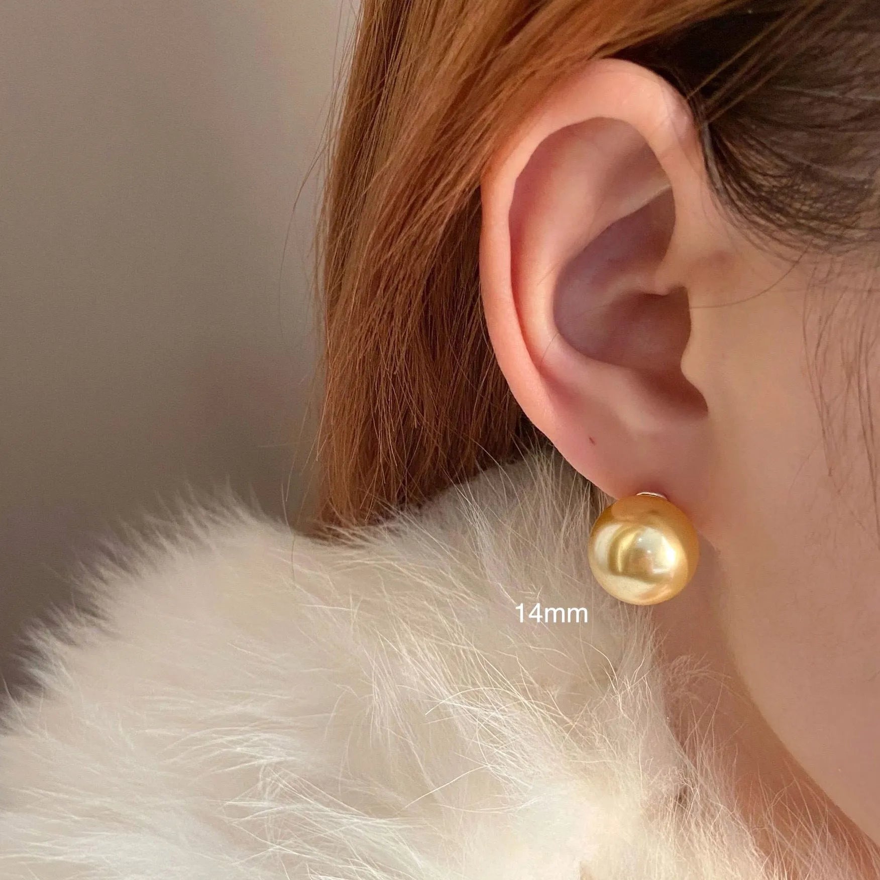 A pair of large pearl stud earrings with a geometric silver setting and an eight-point star detail.