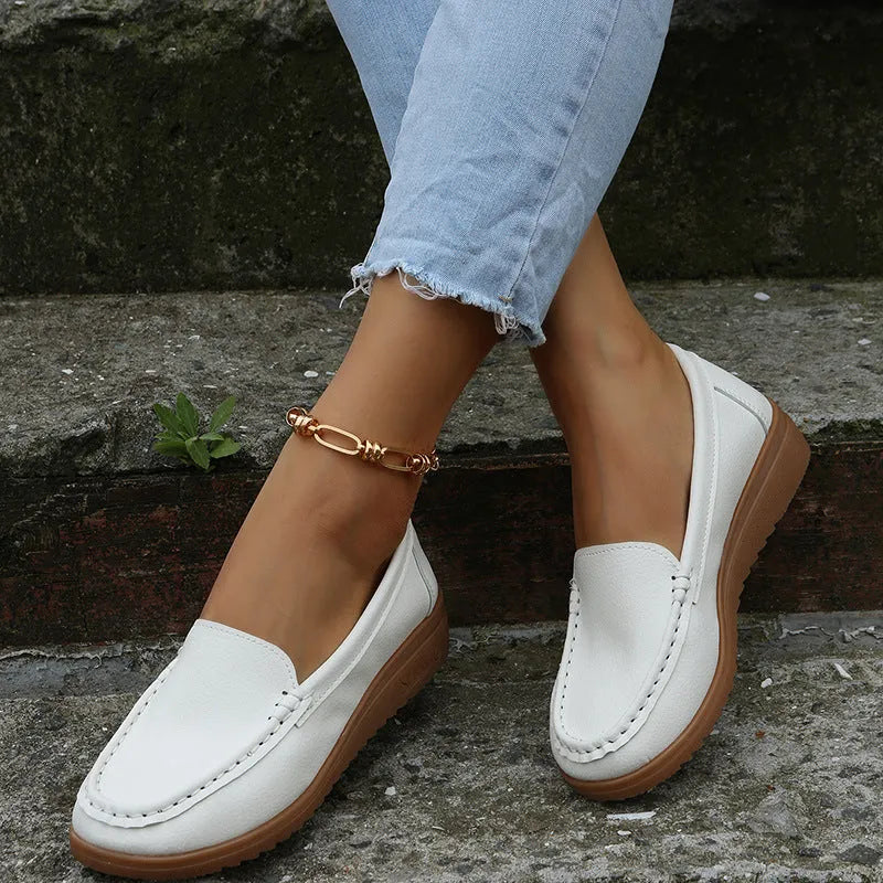 Women's black PU leather flat loafers with round toe and car suture design on a rubber sole.