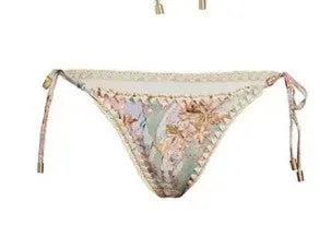 Women's creamy white floral bikini set with halter top, high-waisted briefs and matching skirt