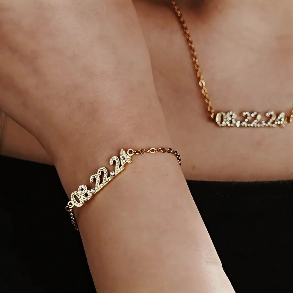 Stainless steel digital bracelet with diamond-studded numbers in gold finish on wrist.