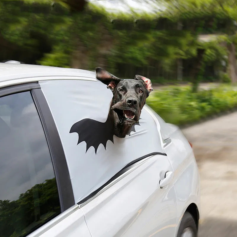 Grey car sun shade curtain with bat pattern and central head hole for dogs, installed on a car window