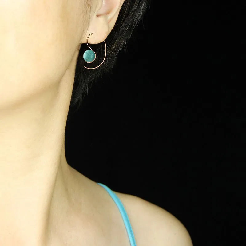 Green turquoise retro style dangle earrings with blue turquoise centrepiece on a white background