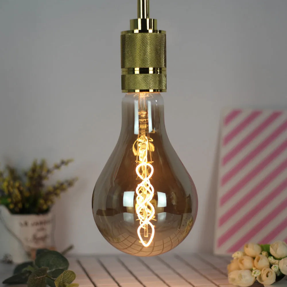 Double helix LED filament bulb in gold finish with spiral design visible through glass housing