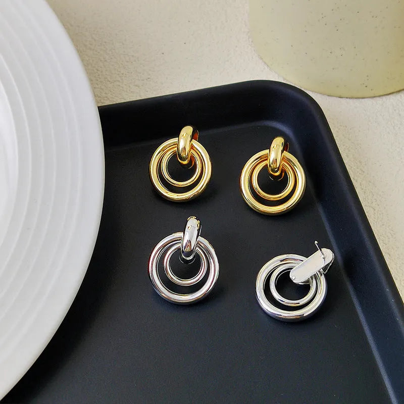 A pair of women's geometric round ring earrings with an irregular shape in a gold electroplated finish.
