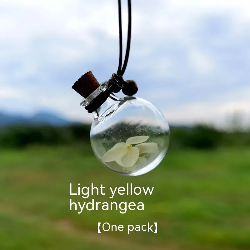 Glass car perfume pendant with preserved flower decoration hanging in car interior