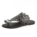 Women's black slip-on sandals with rhinestone details and flip-toe design on a flat rubber sole