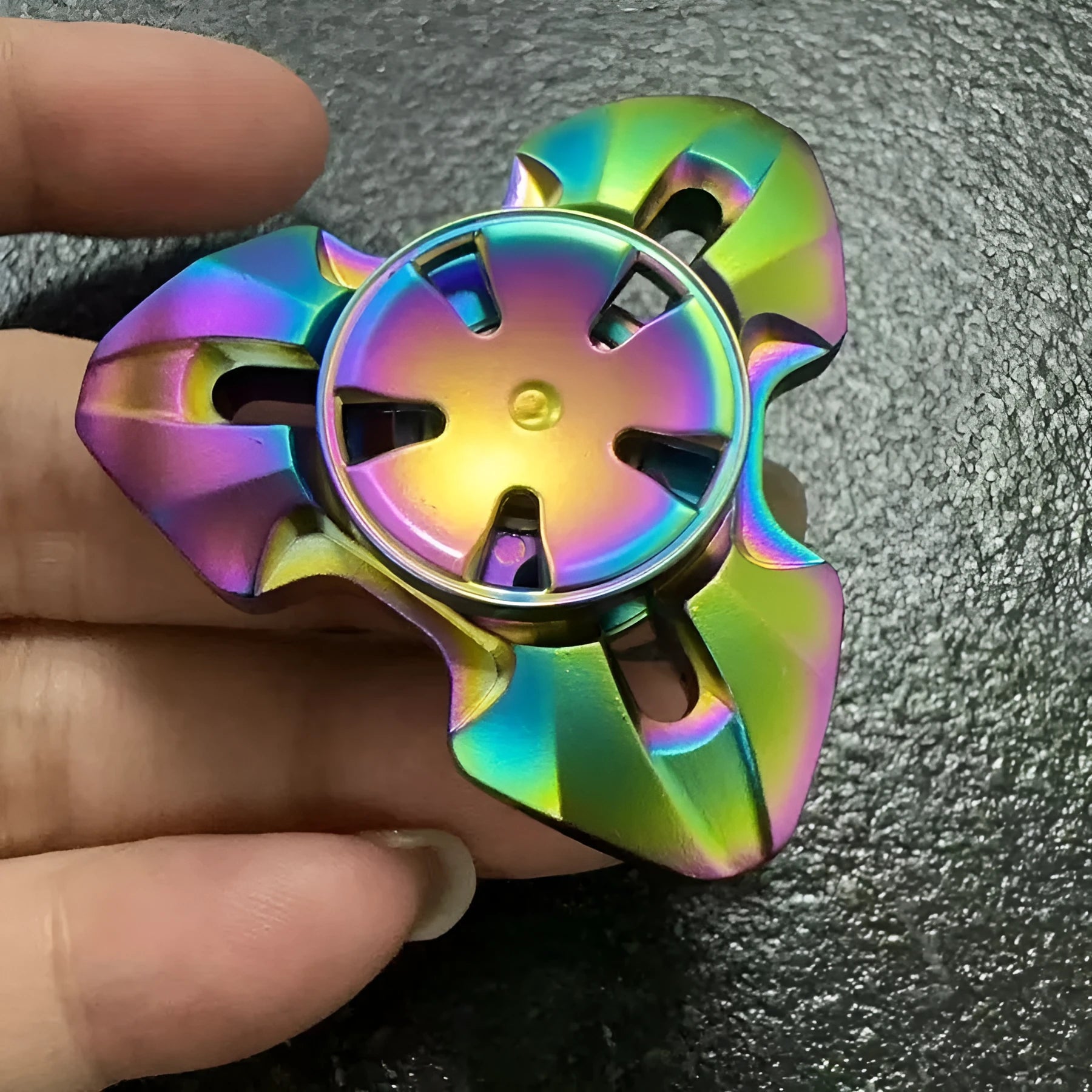 Close-up of a metallic alloy rotating fingertip gyro decompression toy on a table.