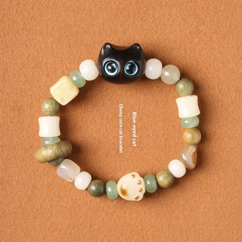 Hand-woven multi-treasure bracelet with Bodhi seeds, jade, and wood beads featuring a cat's paw charm.