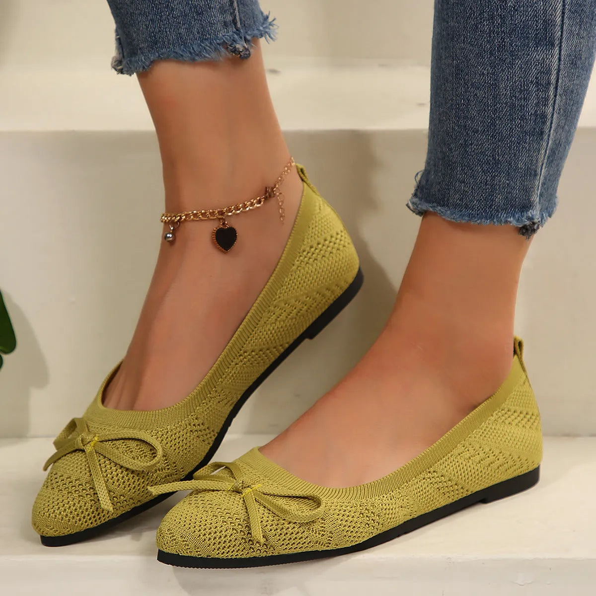 Women's blue knitted loafers with a bow and pointed toe on a flat rubber sole.