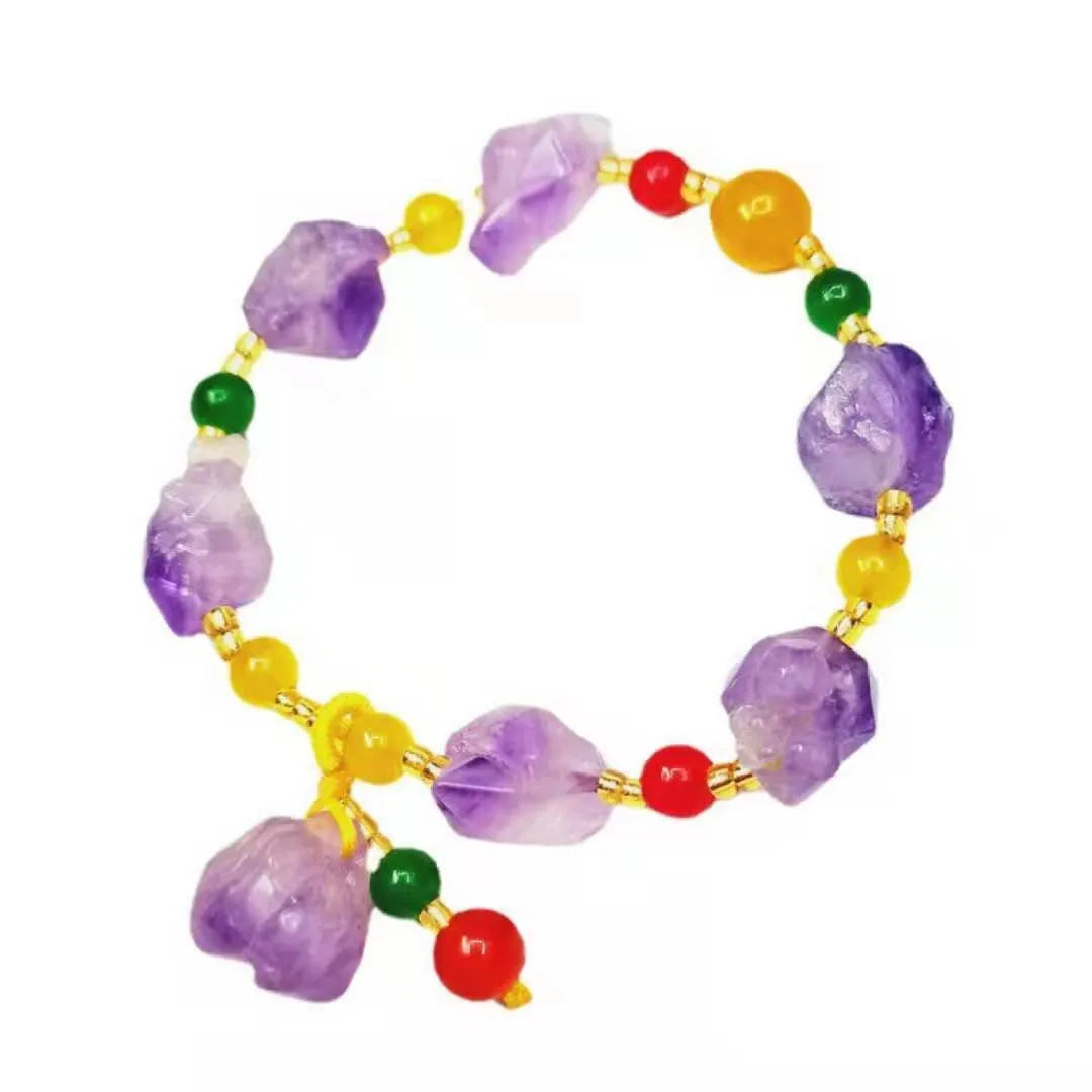 Women's natural amethyst bead bracelet with a fu character charm on a white background.