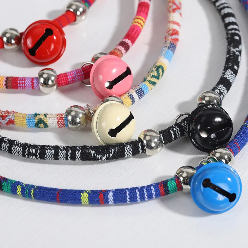 An adjustable ethnic-style pet collar with a metal buckle and bell, shown in various colours.