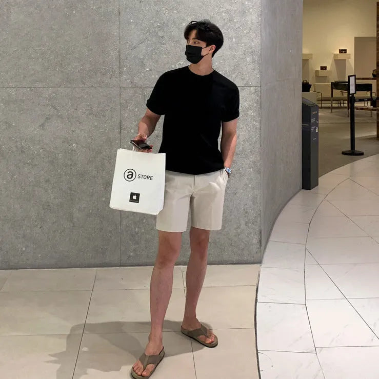 Man wearing solid colour straight-leg casual shorts in a loose fit.