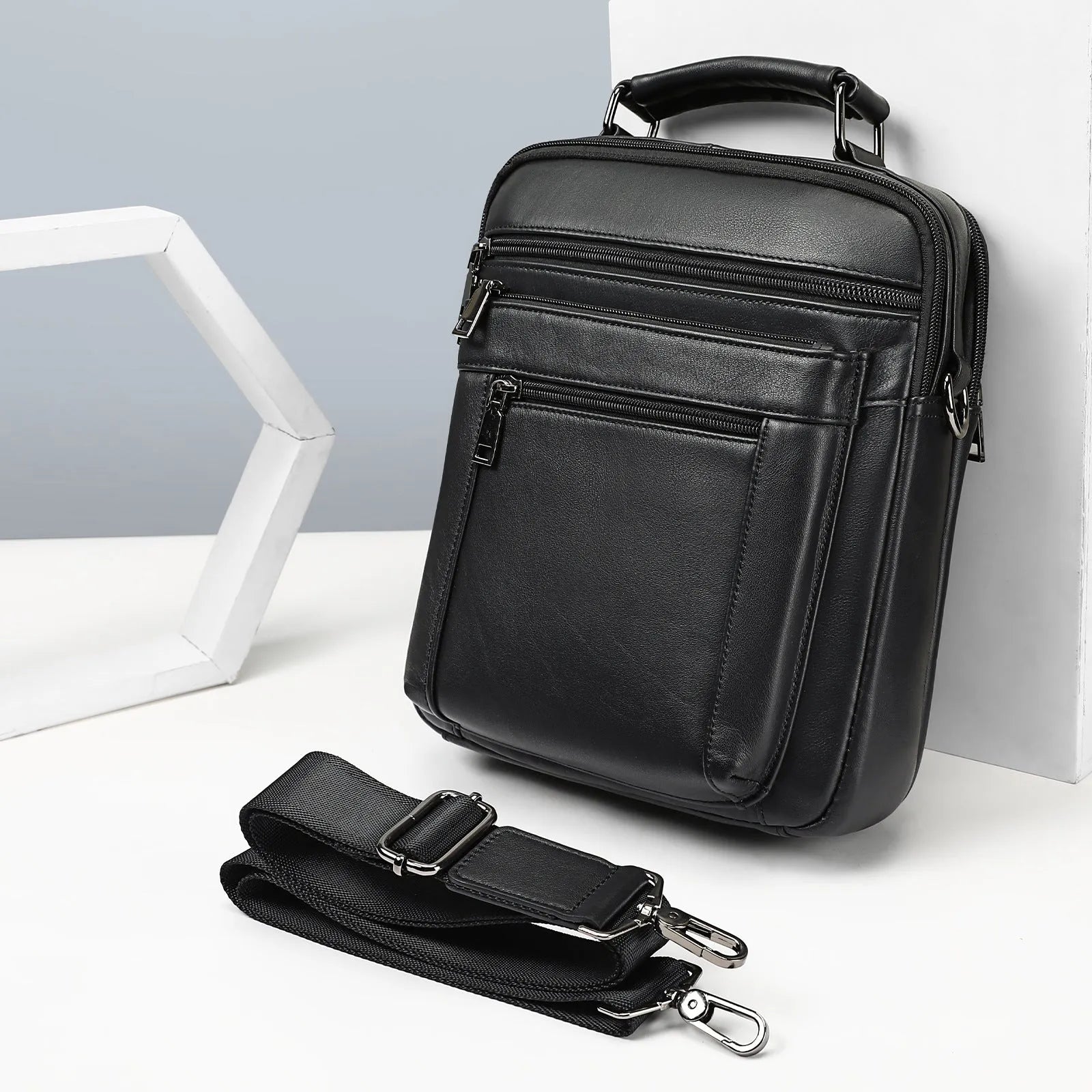 Men's genuine leather messenger bag in black with visible sewing line details and shoulder strap