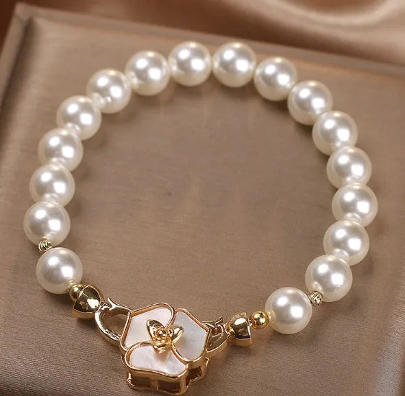White imitation pearl bracelet with floral French-style design on display for women