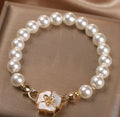 White imitation pearl bracelet with floral French-style design on display for women