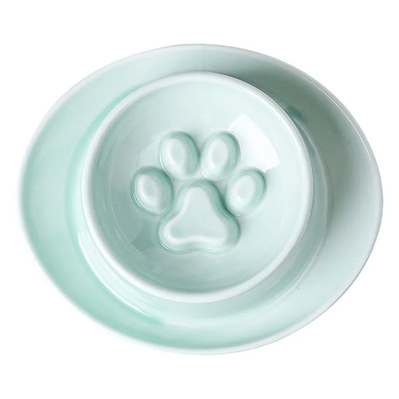 Green ceramic slow feed pet bowl with internal ridges and a raised centre on a white surface.