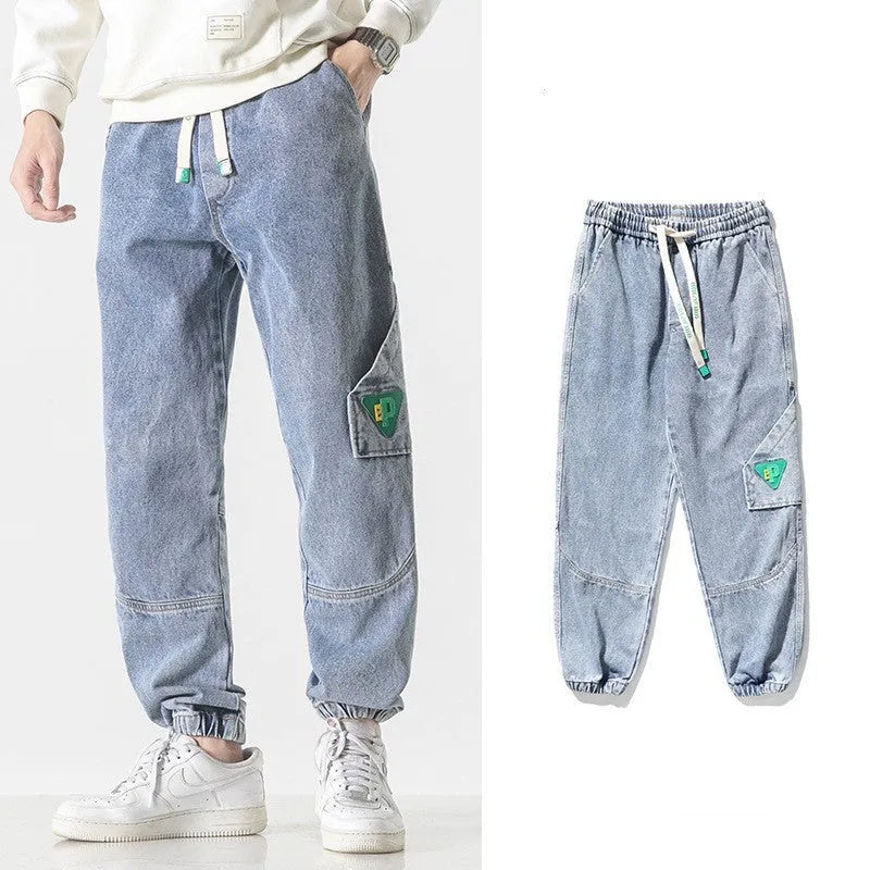 Men's loose-fit tapered cotton trousers in black showing mid-waist design and tapered leg cut