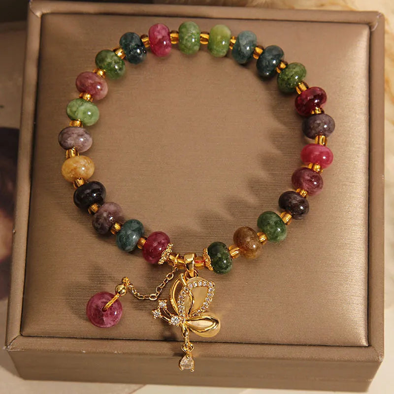 Colourful women's bracelet with a silver butterfly charm, colourful beads, and green tourmaline stones.