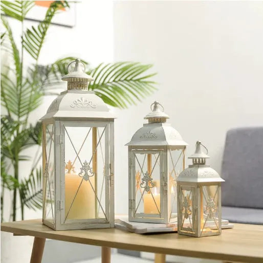 European wrought iron storm lantern with tempered glass in black or white gold finish, shown in small, medium, and large sizes.