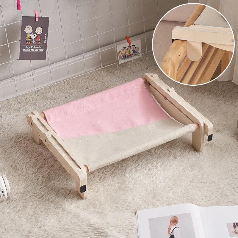 Solid wood cat bed with a removable plaid cushion on a wooden frame.