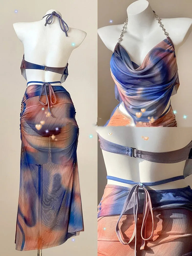 Women's blue printed bikini set with triangle top, bikini pants, and matching skirt laid flat.