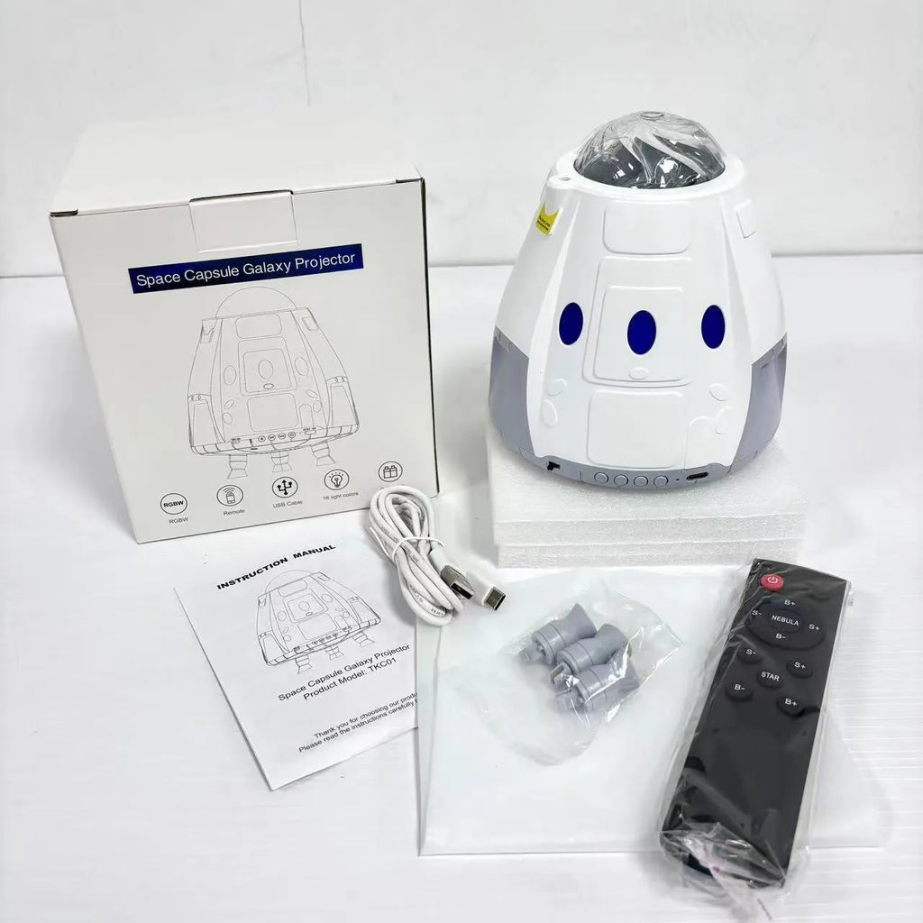 Space capsule shaped projection lamp showing galaxy lighting effects on wall, available in Space Grey or Space White finish