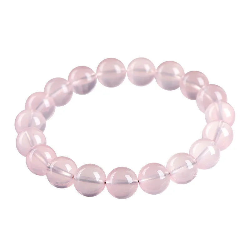A polished natural starlight crystal round bead bracelet in pink, shown in a single circle design.