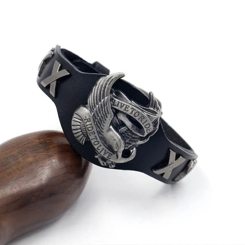 Black geometric leather bracelet with an alloy eagle watch-button clasp, shown flat displaying its 26cm length.