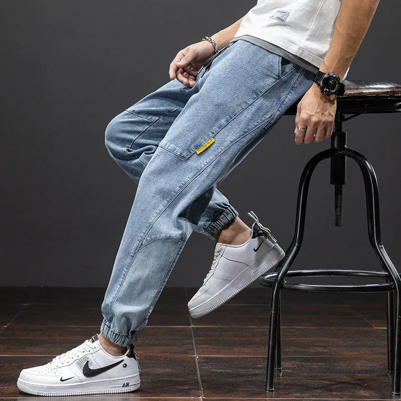 Men's loose straight-leg cargo casual jeans in blue, showing cargo pockets and mid-waist fit.
