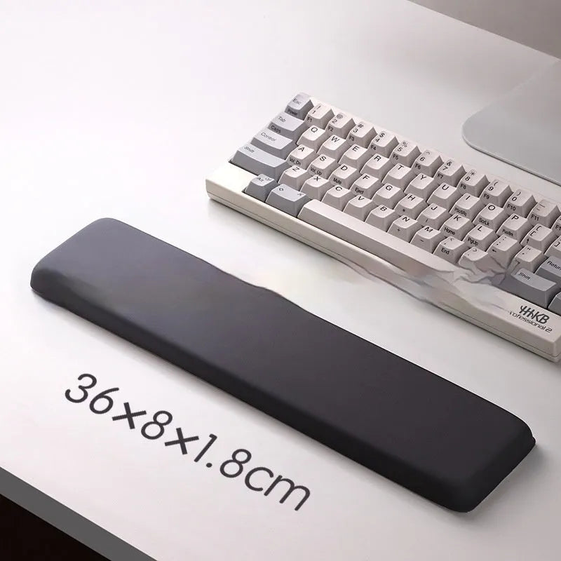Square black silica gel wrist rest mouse pad on a desk, showing cloth surface and raised support pillow.