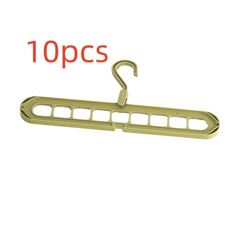Green plastic nine-hole multifunctional clothes hanger for trousers on a white background.