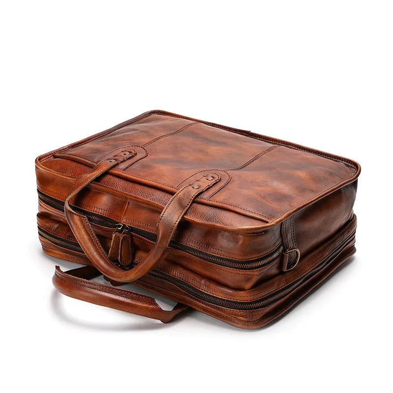 Brown vintage leather men's briefcase showing internal organiser pockets and a shoulder strap.