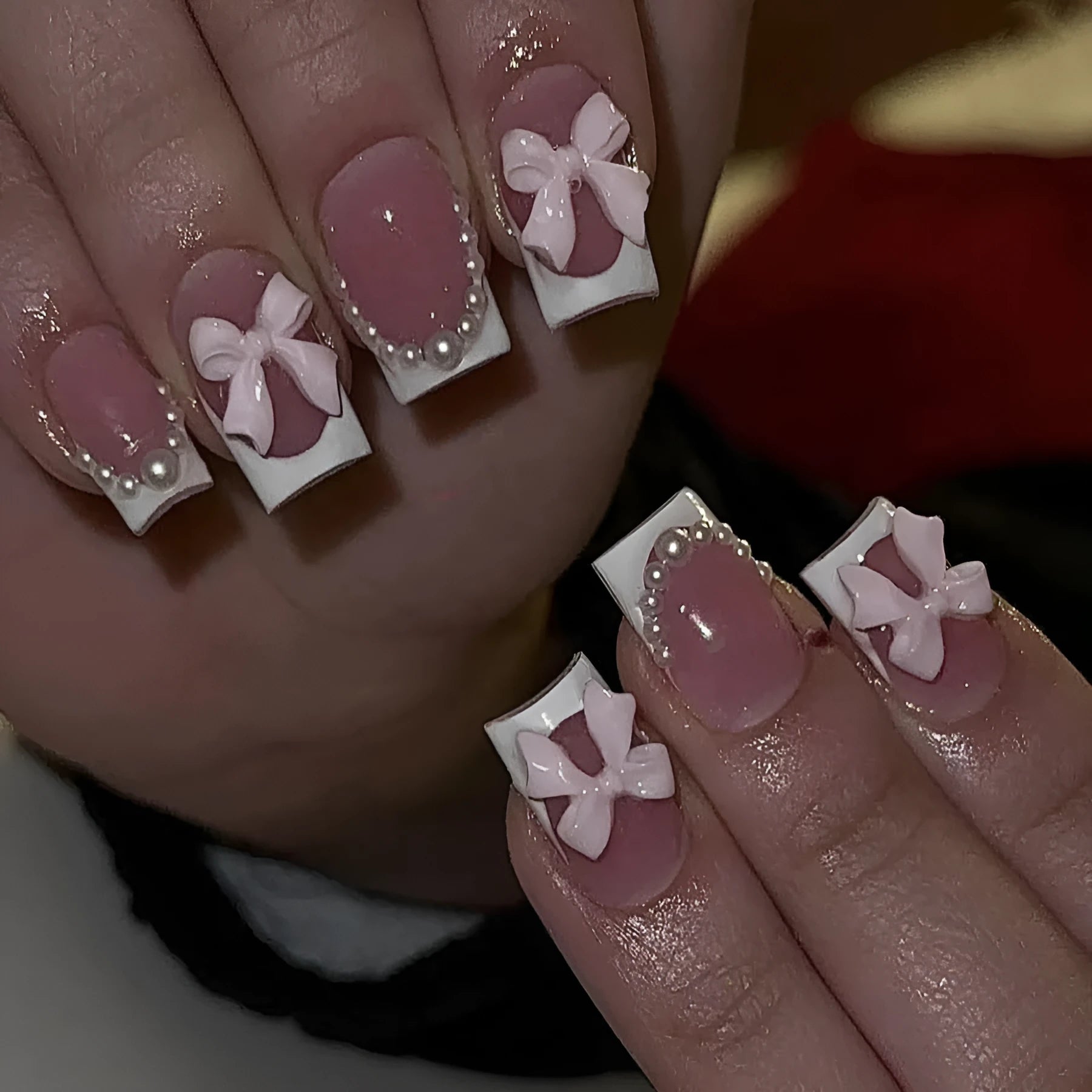 Artificial press-on nails with French manicure style showing bow patterns and tulip designs on short European square nails