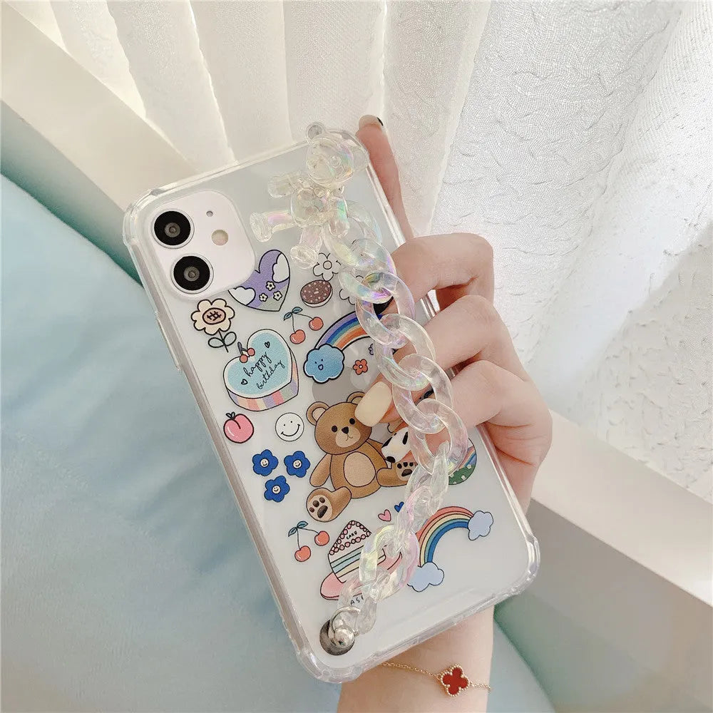 White iPhone case with a bear cartoon design and a silver chain with a bear pendant attached.