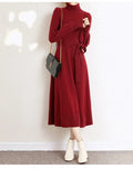 Rose red turtleneck knit dress with long sleeves, elastic waist, and loose mid-length sweater skirt hem.