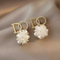 White acrylic DO letter embroidered ball stud earrings for women on light background
