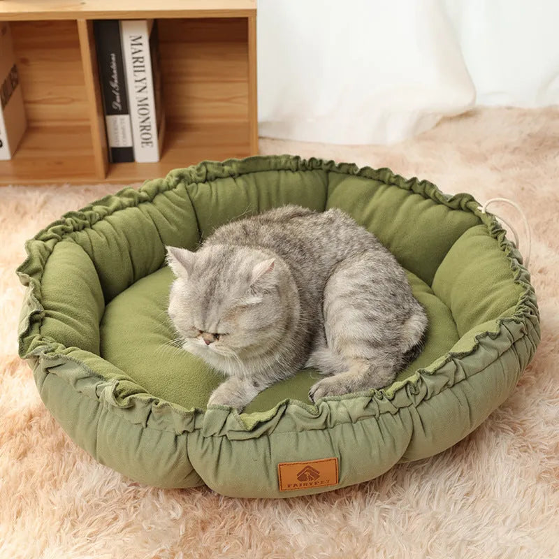 Grey and green reversible donut-shaped pet bed for cats and small dogs on a wooden floor.