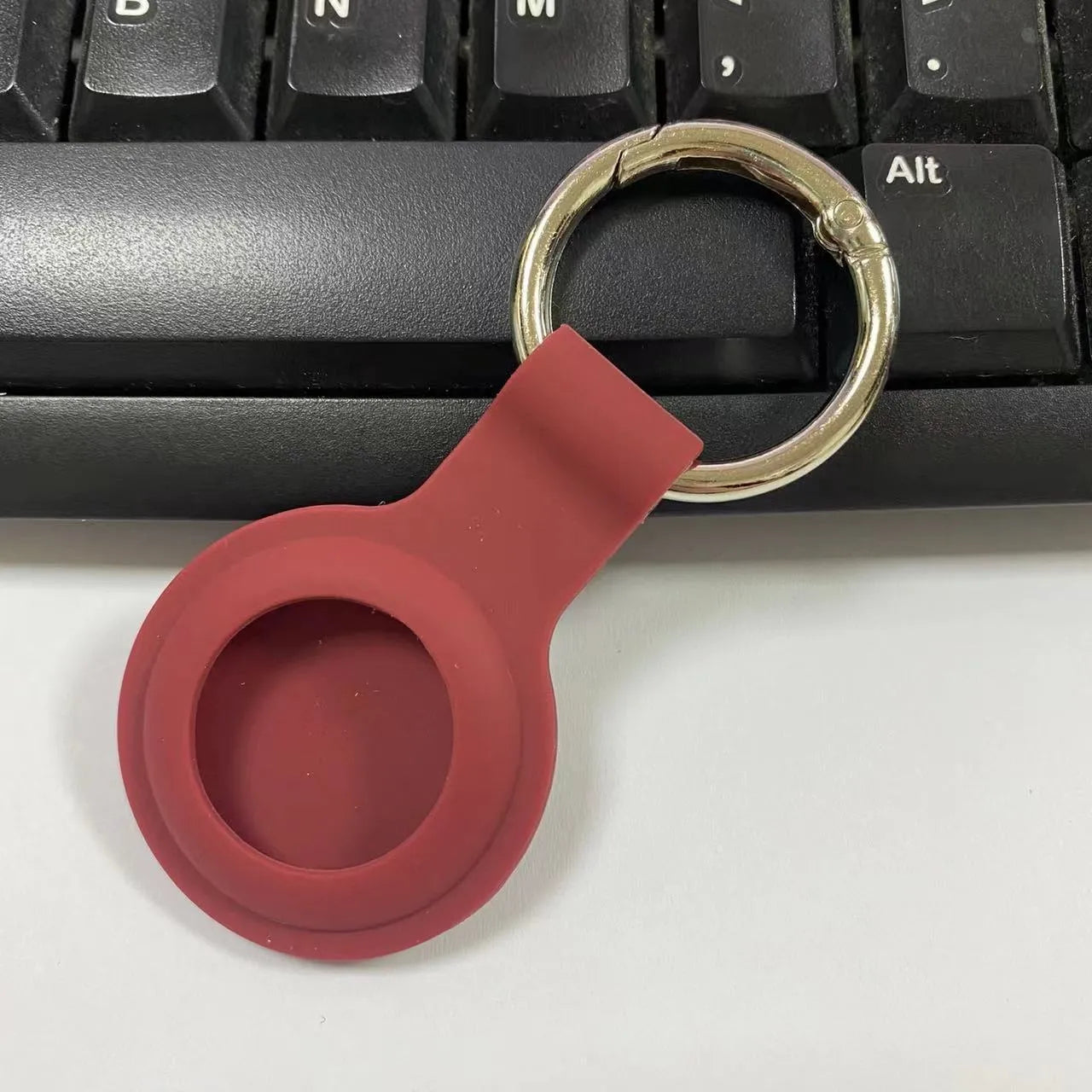 Silicone protective case with metal keychain snap for Apple AirTag in multiple colours.